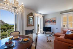 a living room with a chandelier and a table and a couch at The Elite Corfu Luxury Apartment in Corfu