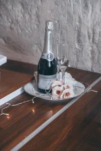 a bottle of wine and a plate with a glass at Bellavita Rooms- Isabel luxury Suite in Matera