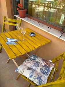 a yellow table with two wine glasses and a chair at Cozy studio in Sunny beach in Sunny Beach