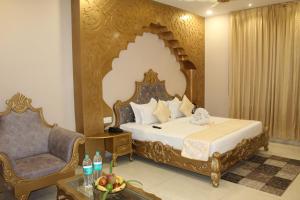 SīkarHotel Annpurna Regency的一间带床和椅子的酒店房间
