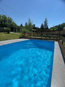 a swimming pool with blue water in a backyard at Iskra DDUR in Gornji Milanovac