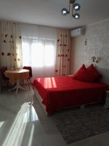 a bedroom with a red bed and a table at Apartament IRI Băile Herculane in Băile Herculane
