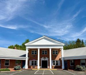 a red brick building with a white roof at Governor House Inn Arlington/Falls Church in Falls Church