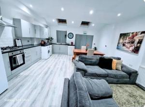 a living room with two couches and a kitchen at Room 5 Shared House in L7 in Liverpool