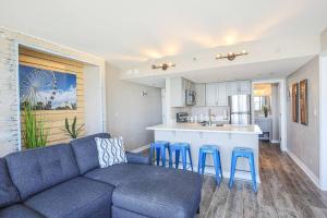 een woonkamer met een blauwe bank en een keuken bij WINTER RATES! Unique Oceanfront Luxury Suite, Dogs Welcome! 406 in Myrtle Beach