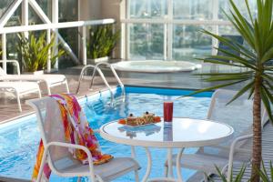 a table and chairs next to a swimming pool at Hotel Sequoia Alphaville in Barueri