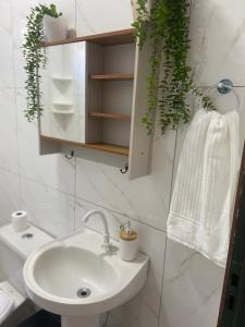 a white bathroom with a sink and a mirror at casa de veraneio jalapão in São Félix do Tocantins