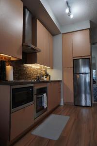 a kitchen with wooden cabinets and a stainless steel refrigerator at Downtown Toronto Condo with CN Tower View in Toronto +11 photos