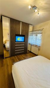 a bedroom with a bed and a flat screen tv at SHoliday Parter Clădire Nouă Spațiu Modern & Parcare Privată in Dumbrăviţa