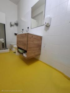 łazienka z toaletką z lustrem i żółtą podłogą w obiekcie Casa Friend w mieście Castel di Sangro