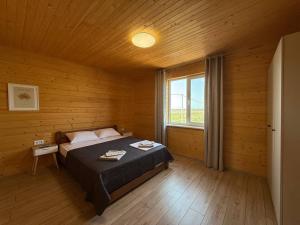 a bedroom with a bed in a wooden room at Тиха Хвиля in Gribovka