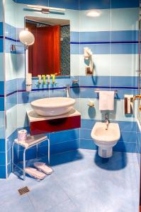 a blue and white bathroom with a sink and a toilet at Taormina Panoramic Hotel in Taormina