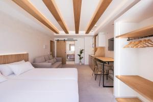 a bedroom with a white bed and a kitchen at Malacosta Sky Suites - MC Apartments Ibiza in Ibiza Town