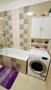 a kitchen with a washer and dryer in a bathroom at SHoliday Parter Clădire Nouă Spațiu Modern & Parcare Privată in Dumbrăviţa +47 photos