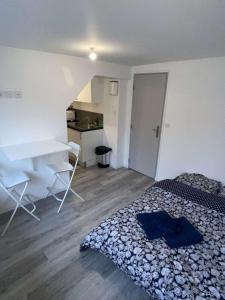 Un dormitorio con una cama, un escritorio y una mesa. en Studio B lumineux refait à neuf cœur historique de Troyes, en Troyes