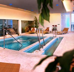 a large swimming pool in a building with a swimming pool at Hotel Airone - Ombrellone incluso al bagno Dolce Vita a Marina dal 15 giugno al 15 settembre in Grosseto
