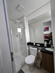 a bathroom with a shower and a toilet and a sink at Studio 306, decorado com garagem e ar-condicionado in Paranaguá +5 photos