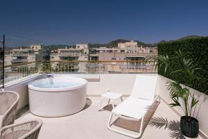 a hot tub on a balcony with chairs and a view at Malacosta Sky Suites - MC Apartments Ibiza in Ibiza Town