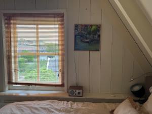 a bedroom with a bed and a window with a picture at Loft - Stadsplekje in Schagen