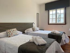 a bedroom with two beds and a window at La Huella de Caldas in Caldas de Reis
