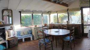 a dining room with a table and chairs and windows at Maison jardin plage Côte Basque in Bidart