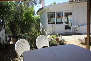 two white chairs and a table in front of a house at Maison jardin plage Côte Basque in Bidart +4 photos