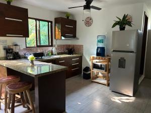 a kitchen with a refrigerator and a counter with stools at blue angel 3 in Playa del Carmen