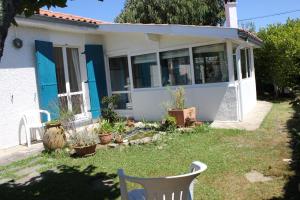 a house with blue doors and a chair in the yard at Maison jardin plage Côte Basque in Bidart