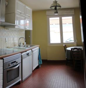 a kitchen with white cabinets and a sink and a window at Maison jardin plage Côte Basque in Bidart
