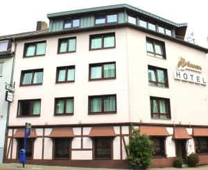 un gran edificio blanco con un cartel de hotel en Brunnen Hotel, en Essen