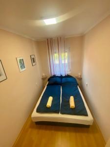 a small bedroom with a blue bed in a room at Kuckó Zóna Balatonfenyves in Balatonfenyves