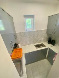 a small kitchen with an orange basket on the counter at Kuckó Zóna Balatonfenyves in Balatonfenyves
