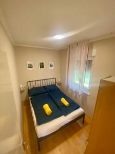 a bedroom with a bed with two yellow pillows at Kuckó Zóna Balatonfenyves in Balatonfenyves