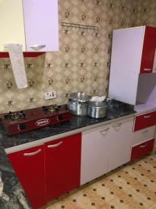 una cucina con piano cottura, pentole e padelle di Allure Guest Inn and Resıdence LTD a Awoyaya