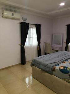 una camera da letto con un letto, una sedia e una finestra di Allure Guest Inn and Resıdence LTD a Awoyaya