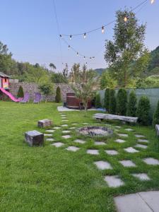 a garden with a fire pit in the grass at Chalet Bora in Vişeu de Jos