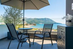 Una mesa y sillas con vista al mar. en Bellemond Hotel & Residences, en Budva