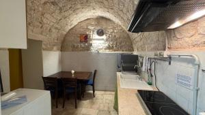 a kitchen with a table and a dining room at Vitti Stone House - 6 minuti dalle Grotte in Castellana Grotte