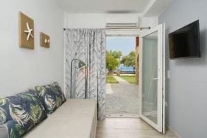 a living room with a couch and a sliding glass door at Kalliston Beach Apartments in Limenas