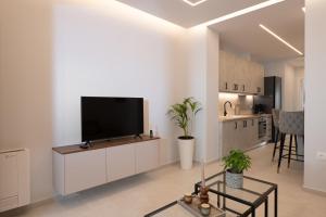 a living room with a flat screen tv on a cabinet at Urban Loft Chalkida in Chalkida