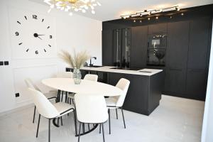 a kitchen with a table and chairs and a clock at Luxury Apartment Antoni in Podstrana