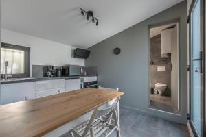 a kitchen with a wooden table in a room at Les clés du bassin in Lège-Cap-Ferret +9 photos
