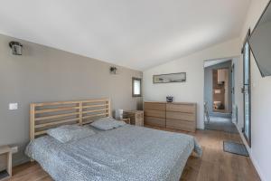 a bedroom with a bed and a staircase at Les clés du bassin in Lège-Cap-Ferret