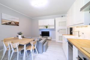 a kitchen and dining room with a table and chairs at Baltic Cliff Apartment- Babie Doły in Gdynia