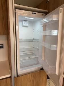 an empty refrigerator with its door open in a kitchen at 1 Bed Junior near Cleveland and Galleria Mall by Central Stay in Abu Dhabi