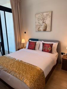 a bedroom with a large bed with red pillows at 1 Bed Junior near Cleveland and Galleria Mall by Central Stay in Abu Dhabi +36 photos
