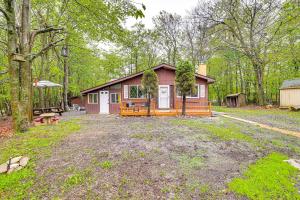 a small cabin in the middle of a forest at Pool and Lake Access Family Poconos Cabin with Deck in Tobyhanna