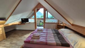 a bedroom with a large bed in a attic at Apartments Čebelica in Bohinj