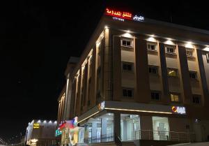 a building with a sign on top of it at night at شقق الشويش المخدومة - فئة اقتصادي in Taif