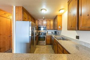 uma cozinha com armários de madeira e um frigorífico branco em 154 Bldg D townhouse em Truckee